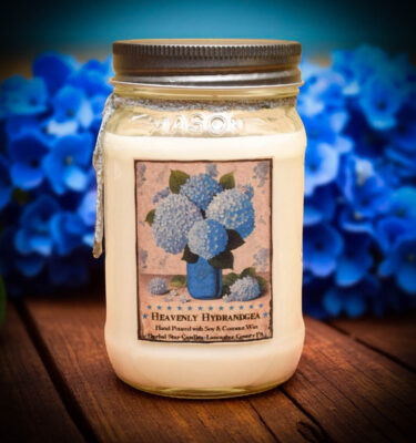 Heavenly Hydrangea 16 oz floral candle with a bright blue hydrangea label, featuring a soft, powdery scent.