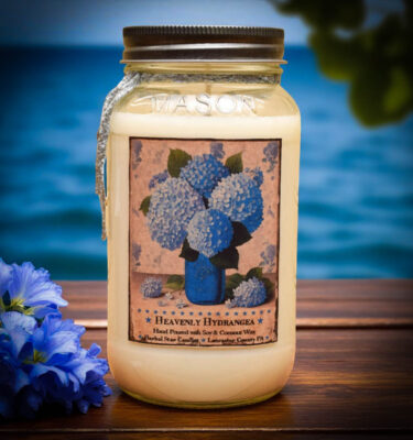 Heavenly Hydrangea 24 oz floral candle with a bright blue hydrangea label, featuring a soft, powdery scent.