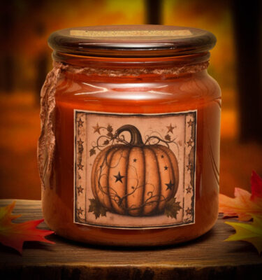 Amber jar candle with a rustic orange pumpkin and star folk art label, perfect for fall farmhouse style.