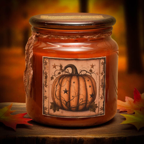 Amber jar candle with a rustic orange pumpkin and star folk art label, perfect for fall farmhouse style.