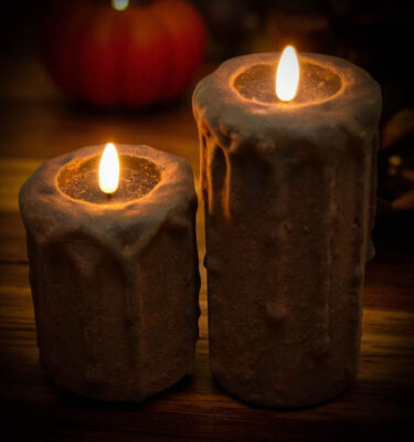 Blackened primitive flameless candles with spice coating and realistic flickering flame in fall setting