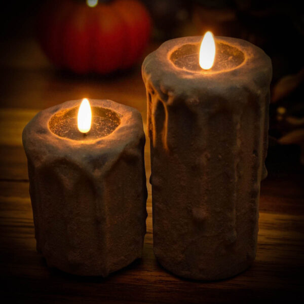 Blackened primitive flameless candles with spice coating and realistic flickering flame in fall setting
