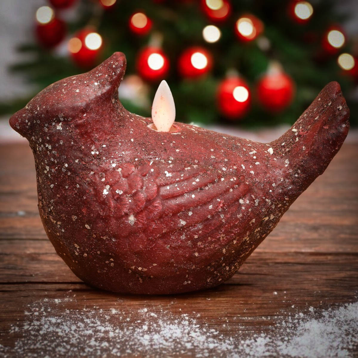 Cardinal moving flame candle with cinnamon-scented wax and mica glitter on wooden table