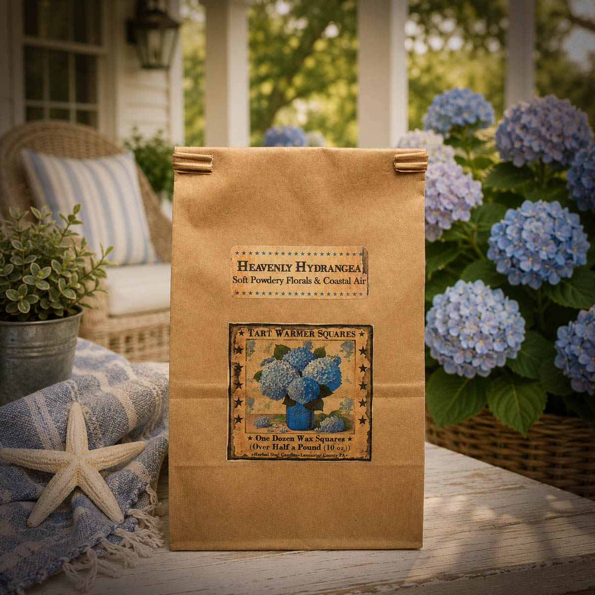 Heavenly Hydrangea wax tart melters in a 10 oz bag displayed on a coastal cottage porch surrounded by blooming blue hydrangeas.