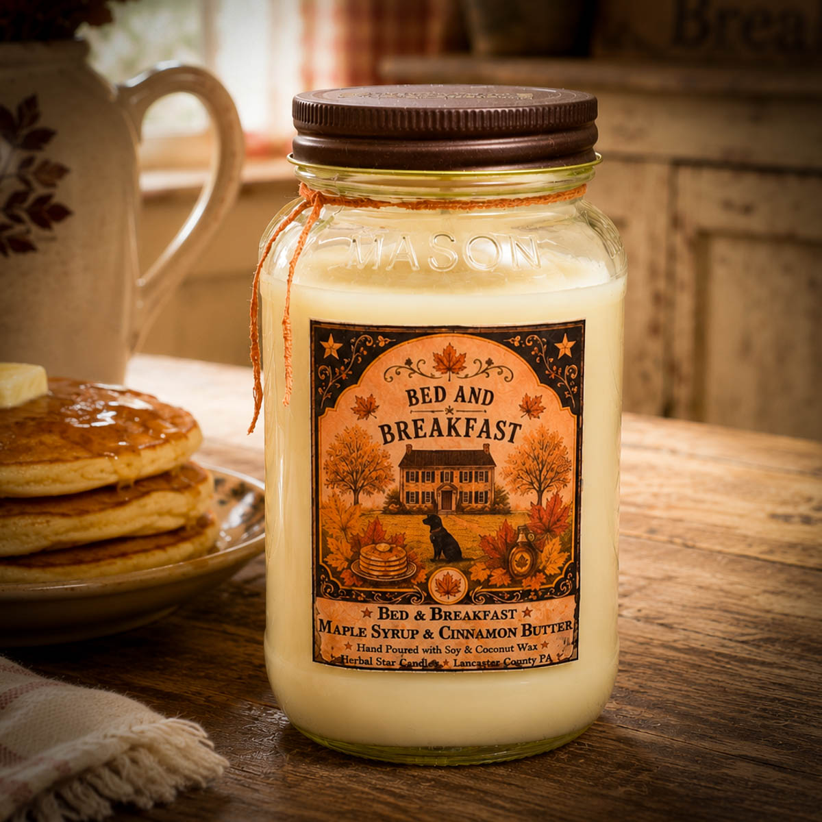 Bed and Breakfast 24 oz Candle with maple syrup and cinnamon butter fragrance displayed on a rustic farmhouse breakfast table with pancakes.